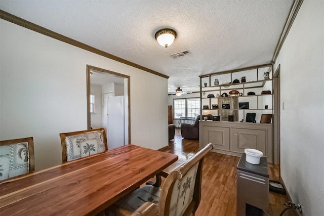 5411 Pecan St, Crosby, TX 77532 - dining space with ceiling fan, ornamental molding, dark hardwood / wood-style floors, and a textured ceiling
