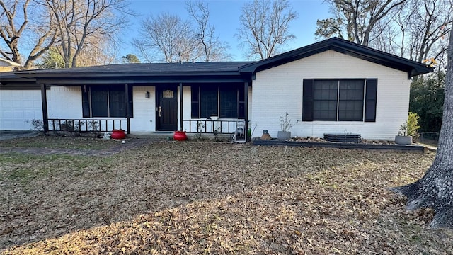 single story home featuring a garage and a porch