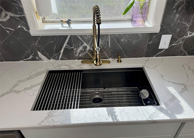 interior details featuring sink and white cabinets