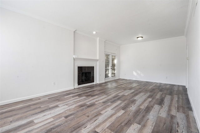 unfurnished living room featuring ornamental molding, a premium fireplace, and light wood-type flooring