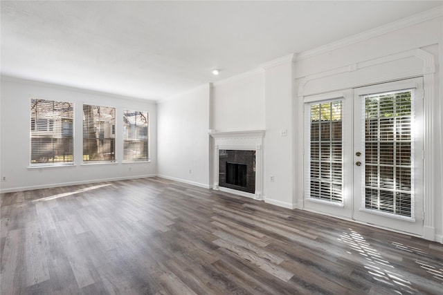 unfurnished living room with crown molding, a premium fireplace, dark hardwood / wood-style flooring, and french doors