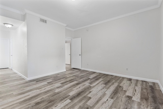 empty room with crown molding and light wood-type flooring