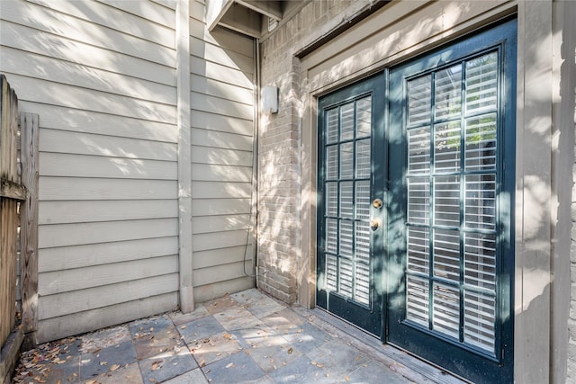 view of exterior entry with a patio area and french doors