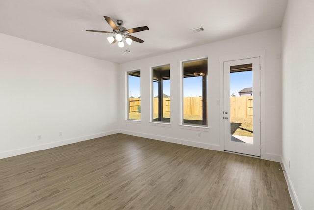 unfurnished room with ceiling fan and dark hardwood / wood-style floors