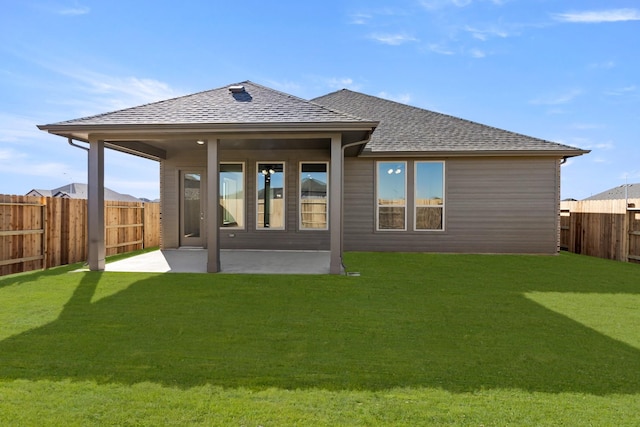 rear view of house featuring a patio and a yard