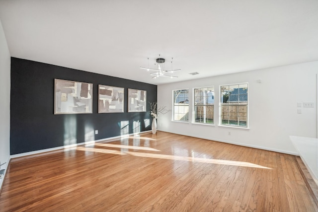 unfurnished room featuring wood-type flooring and a chandelier