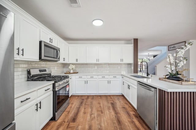 kitchen featuring sink, dark hardwood / wood-style floors, white cabinets, stainless steel appliances, and backsplash