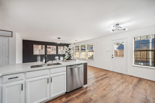 kitchen with dishwasher, sink, white cabinets, a chandelier, and light hardwood / wood-style flooring