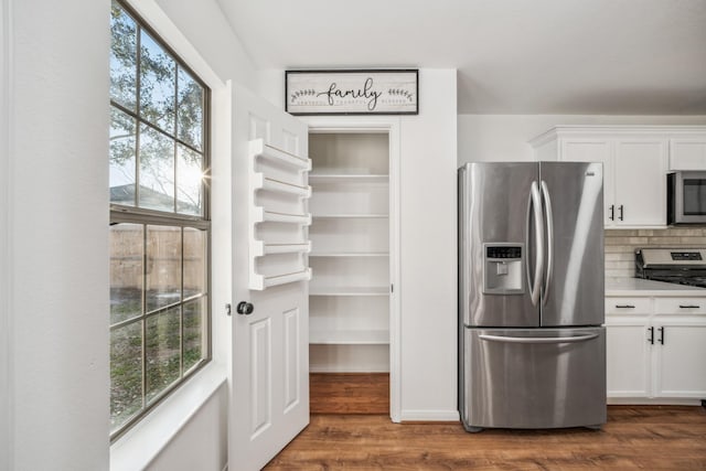 kitchen featuring dark hardwood / wood-style flooring, a healthy amount of sunlight, stainless steel appliances, and white cabinets