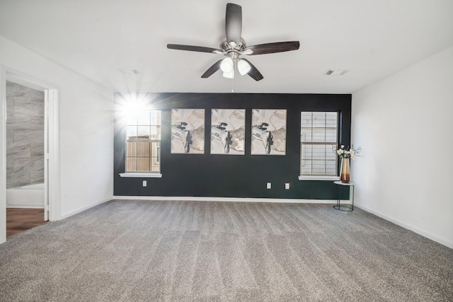 spare room featuring ceiling fan, carpet, and a wealth of natural light