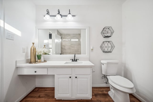 bathroom featuring vanity, wood-type flooring, toilet, and a tile shower