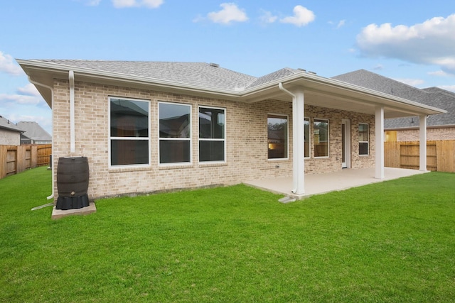 back of property with a patio and a lawn