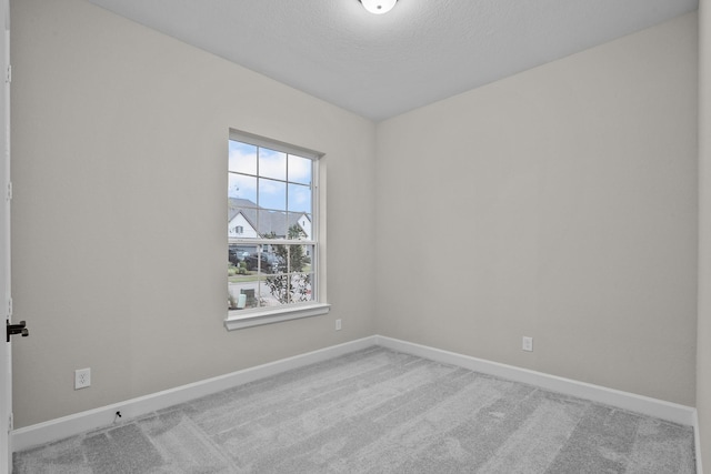 empty room featuring a textured ceiling and carpet flooring