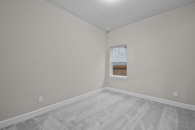 spare room with carpet and a textured ceiling