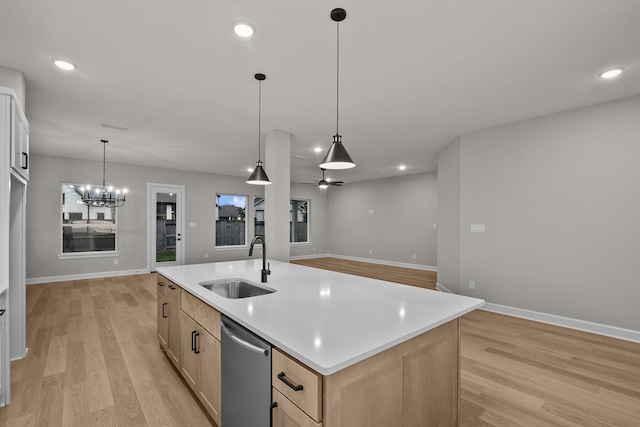 kitchen with sink, dishwasher, a kitchen island with sink, light brown cabinetry, and decorative light fixtures