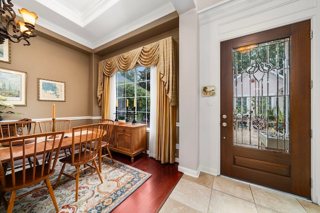 dining area featuring hardwood / wood-style floors, crown molding, a raised ceiling, and a chandelier