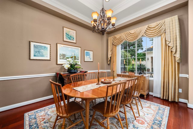 dining area featuring dark hardwood / wood-style floors, ornamental molding, a tray ceiling, and a chandelier