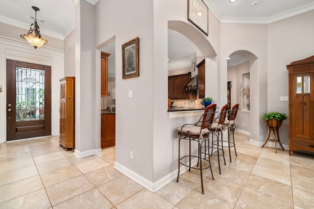 entryway featuring crown molding, a towering ceiling, and light tile patterned flooring