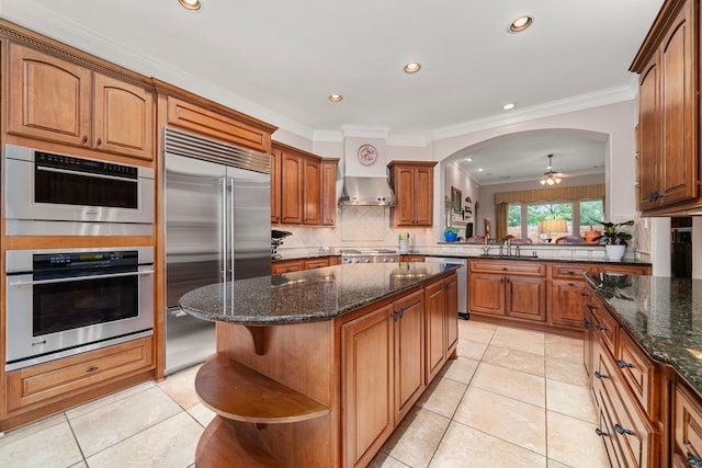 kitchen featuring backsplash, light tile patterned floors, a kitchen island, and appliances with stainless steel finishes