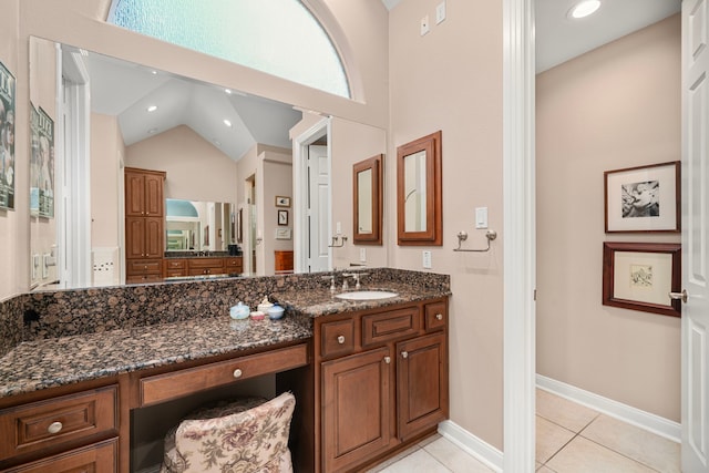 bathroom with vaulted ceiling, vanity, and tile patterned flooring