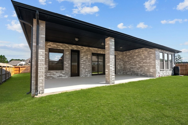 back of house featuring a patio and a lawn