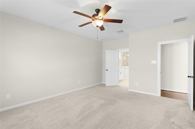 unfurnished bedroom featuring ceiling fan, connected bathroom, and light colored carpet