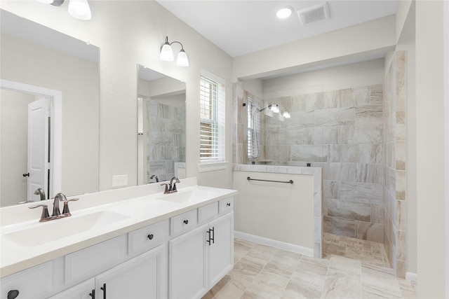 bathroom with tiled shower and vanity