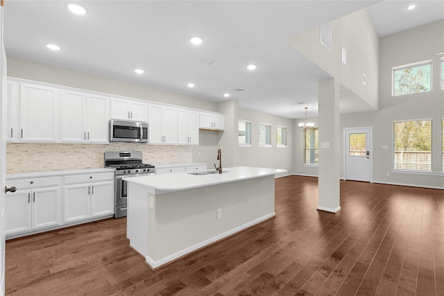 kitchen with sink, white cabinetry, a center island with sink, stainless steel appliances, and decorative backsplash