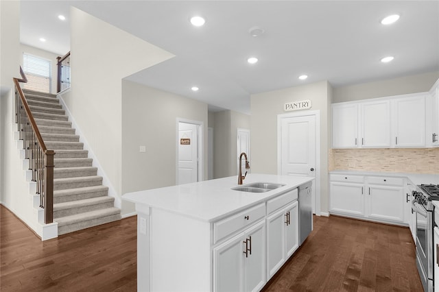 kitchen featuring stainless steel appliances, sink, a center island with sink, and white cabinets