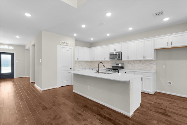 kitchen featuring a kitchen island with sink, sink, white cabinetry, and appliances with stainless steel finishes