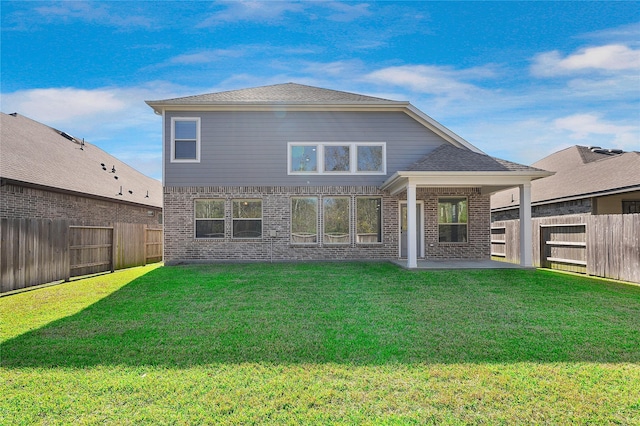 rear view of property featuring a patio area and a lawn