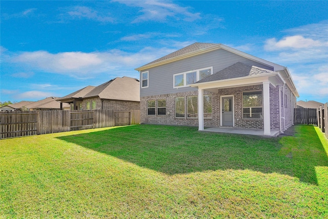 rear view of house with a lawn and a patio area