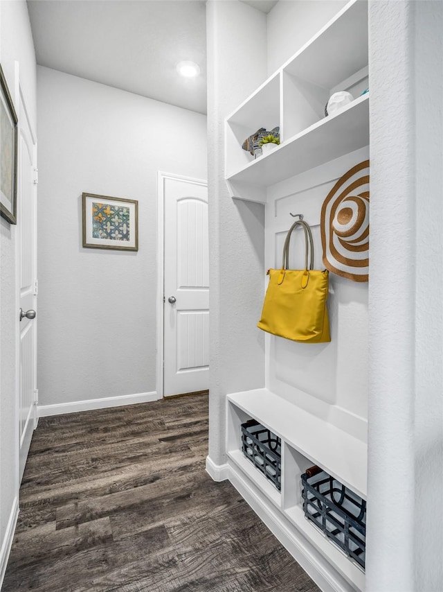 mudroom with dark wood finished floors and baseboards