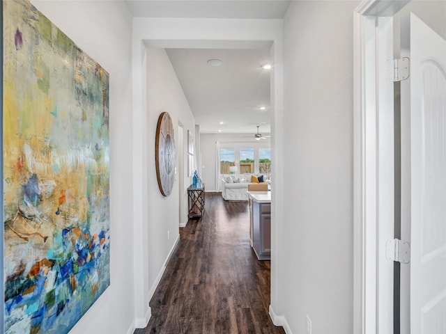 corridor with dark wood-type flooring and baseboards