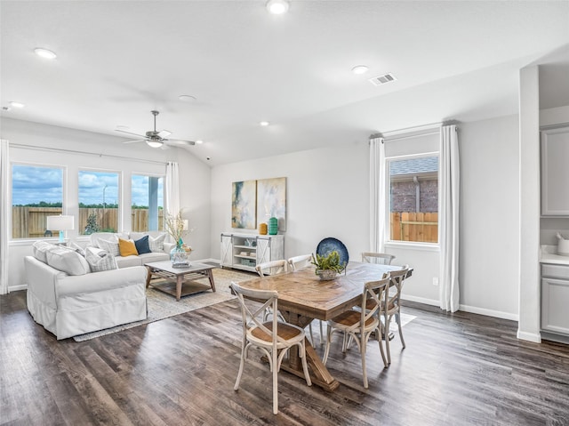 dining area with dark wood-style floors, baseboards, visible vents, and vaulted ceiling