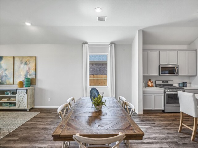 dining space featuring dark wood-style floors, recessed lighting, visible vents, and baseboards