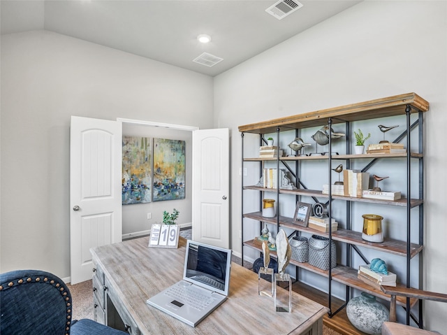 office area featuring lofted ceiling, baseboards, and visible vents