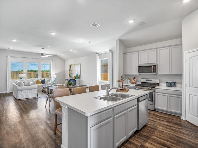 kitchen with dark wood-style flooring, stainless steel appliances, lofted ceiling, visible vents, and gray cabinetry