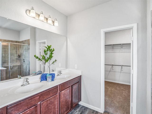 27014 Costa Creek Dr, Katy, TX 77493 - full bath with a stall shower, double vanity, a spacious closet, baseboards, and wood finished floors