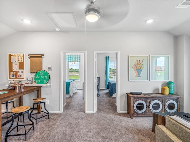 interior space featuring attic access, visible vents, vaulted ceiling, and carpet floors