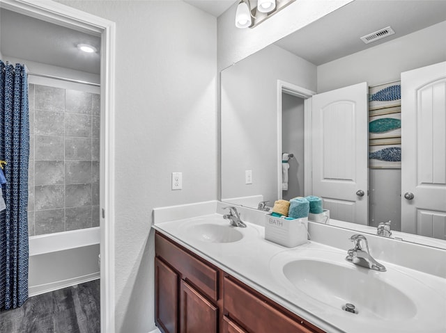 27014 Costa Creek Dr, Katy, TX 77493 - full bath with double vanity, wood finished floors, and shower / bathtub combination with curtain