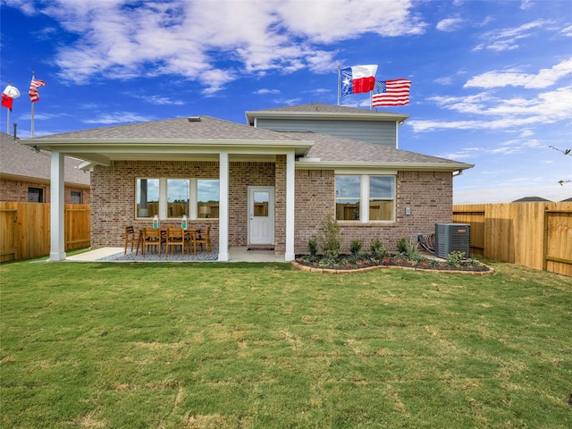 back of house featuring a patio area, a fenced backyard, a yard, and brick siding