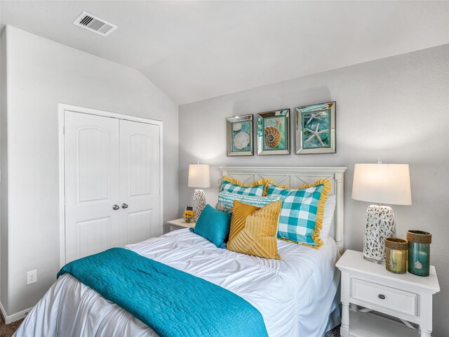 bedroom featuring vaulted ceiling, a closet, and visible vents