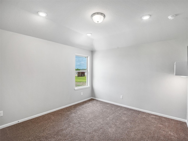 carpeted empty room featuring vaulted ceiling, recessed lighting, and baseboards