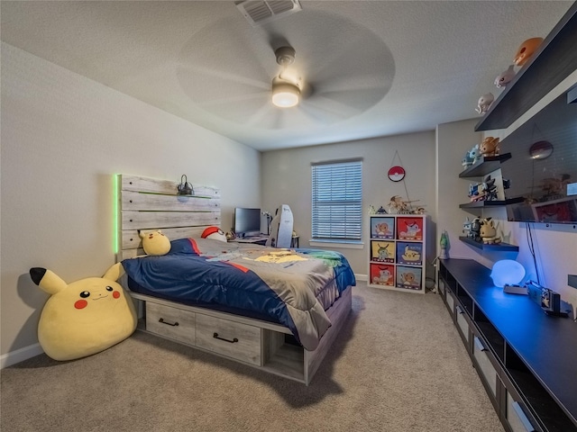 bedroom featuring ceiling fan, a textured ceiling, and carpet