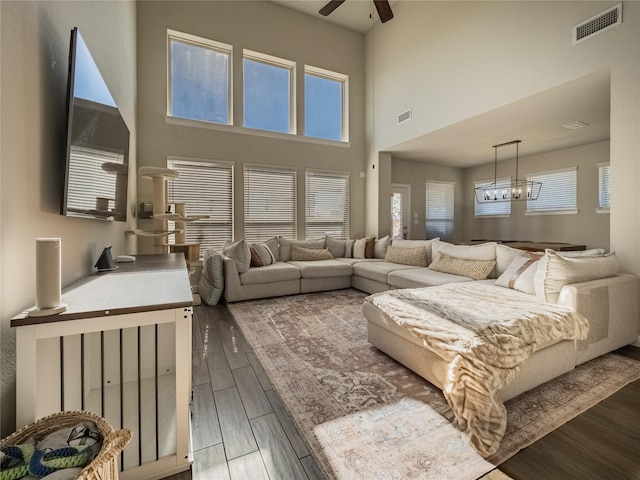 living room featuring hardwood / wood-style flooring and ceiling fan with notable chandelier