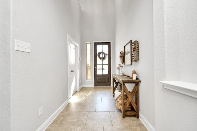 entrance foyer with light tile patterned flooring and a high ceiling