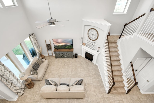 living room with a high ceiling and ceiling fan