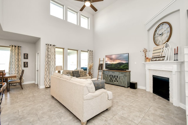 living room with a towering ceiling and ceiling fan