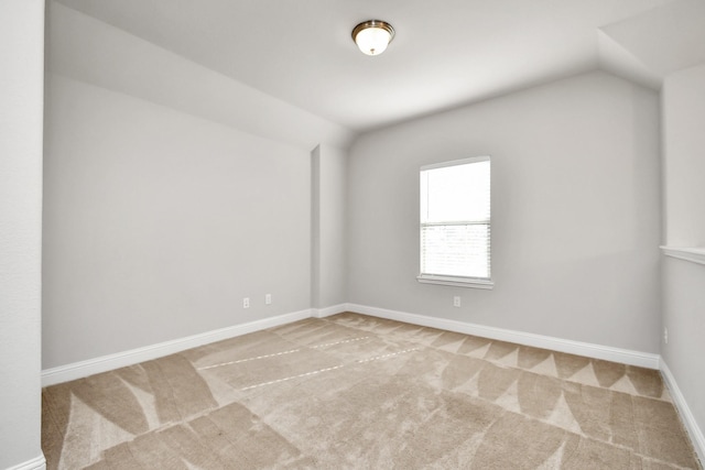 unfurnished room with light colored carpet and lofted ceiling